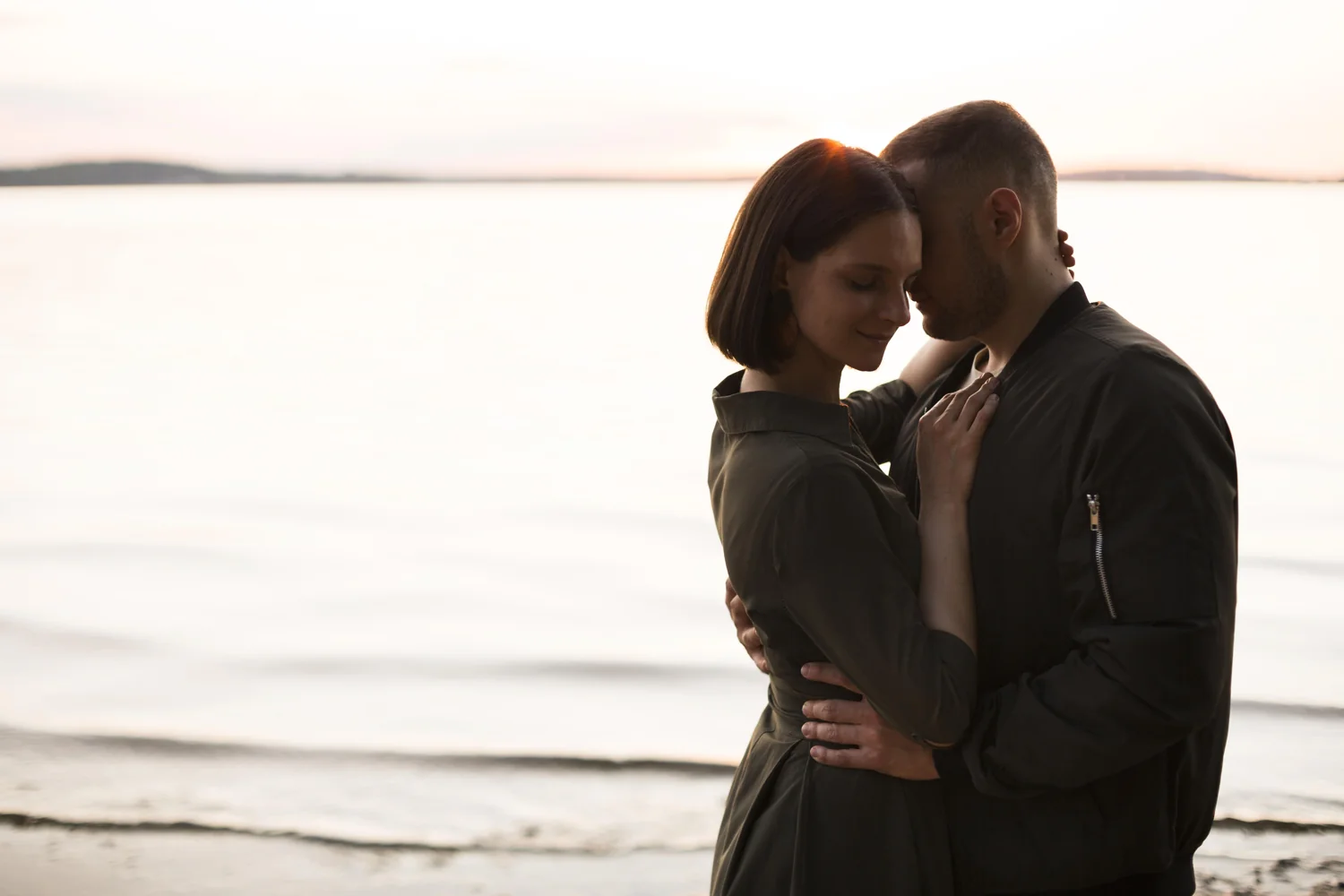 dating Nice — couple in dark clothes beside the water at sunset